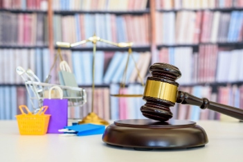 Consumer protection law, rights and guarantees, justice concept : Judge gavel, balance scale, bags, a shopping cart, depicting a safeguard designed to protect buyers from fraudulent business practices
